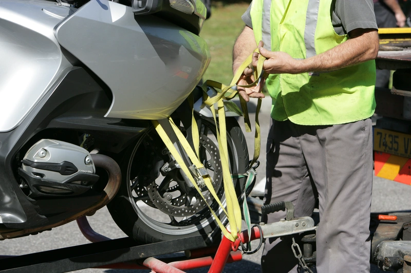 A motorcycle is secured with a tie-down strap